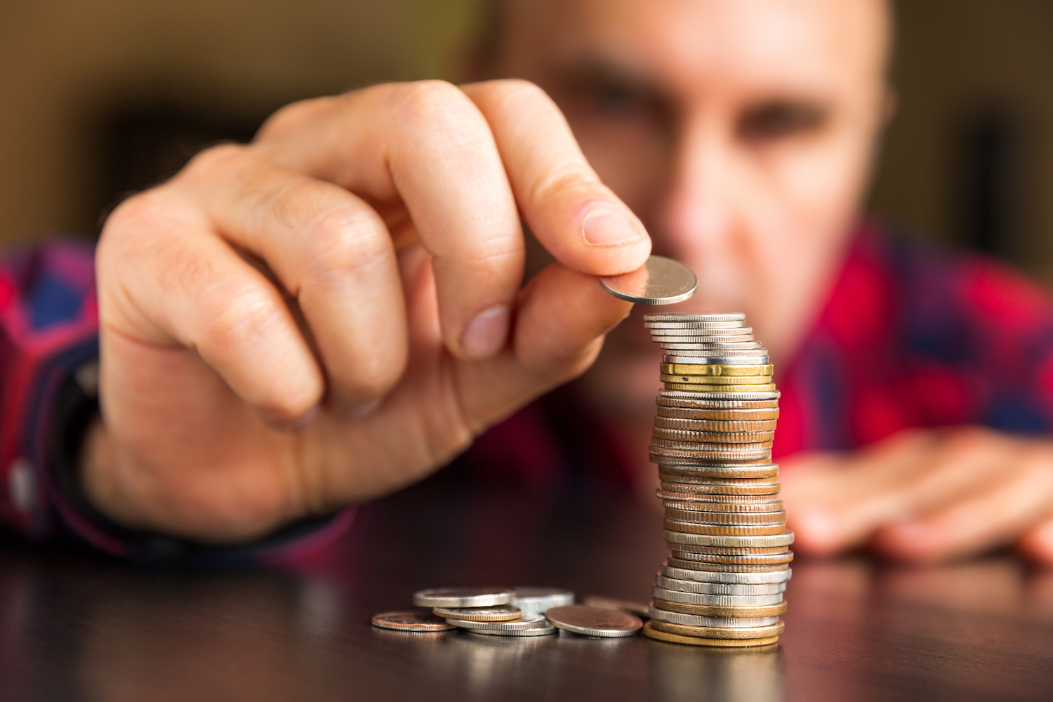 Man mounting pennies n a table. Concept: personal finances.