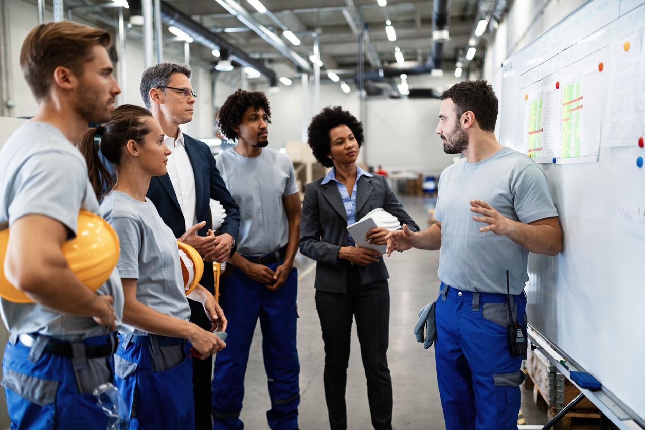 Young factory worker holding presentation about production development to company managers and his coworkers. concept: business continuity plan