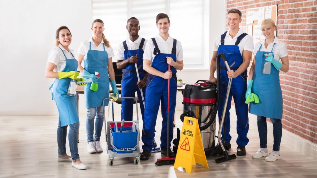 Portrait Of Happy Diverse Janitors In The Office With Cleaning Equipments. concept: cleaning business