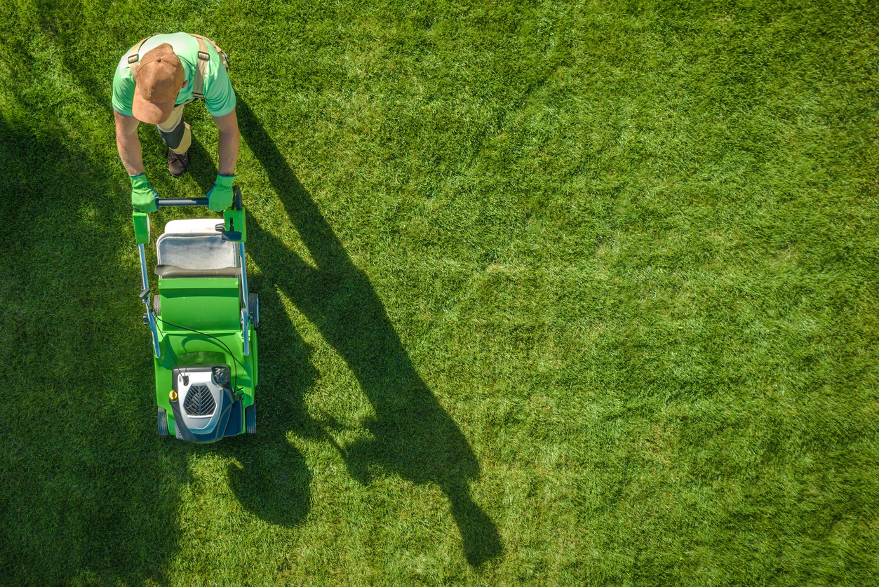 Lawn Moving Aerial Photo. Caucasian Gardener with Gasoline Grass Mower at Work. Landscaping Business. Industrial Theme. concept: Landscaping Business Loans