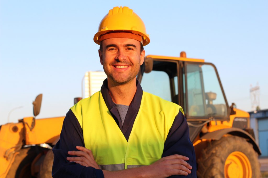 Conductor de construcción con excavadora al fondo. concept: maquinaria de construcción