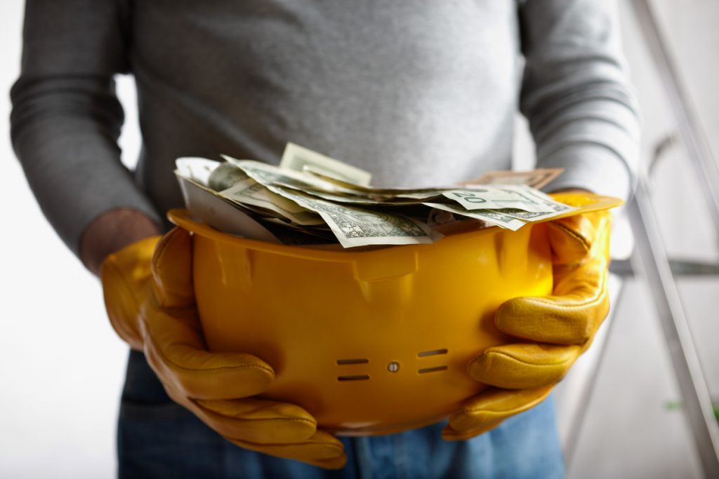concepto financiero, dólares en un casco de construcción amarillo. concept: factoraje de construcción