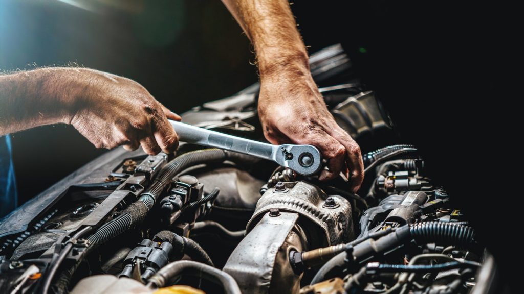 Taller de reparación automotriz, mecánico trabajando en el motor de un coche. concept: programa de reparación directa