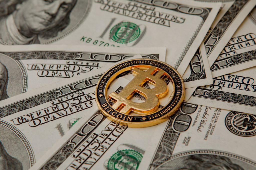 moneda dorada bitcoin sobre billetes, dólares. concept: comprar bitcoin